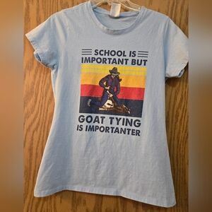 Cute light blue, short sleeve, graphic t shirt with goat tying girl on front.